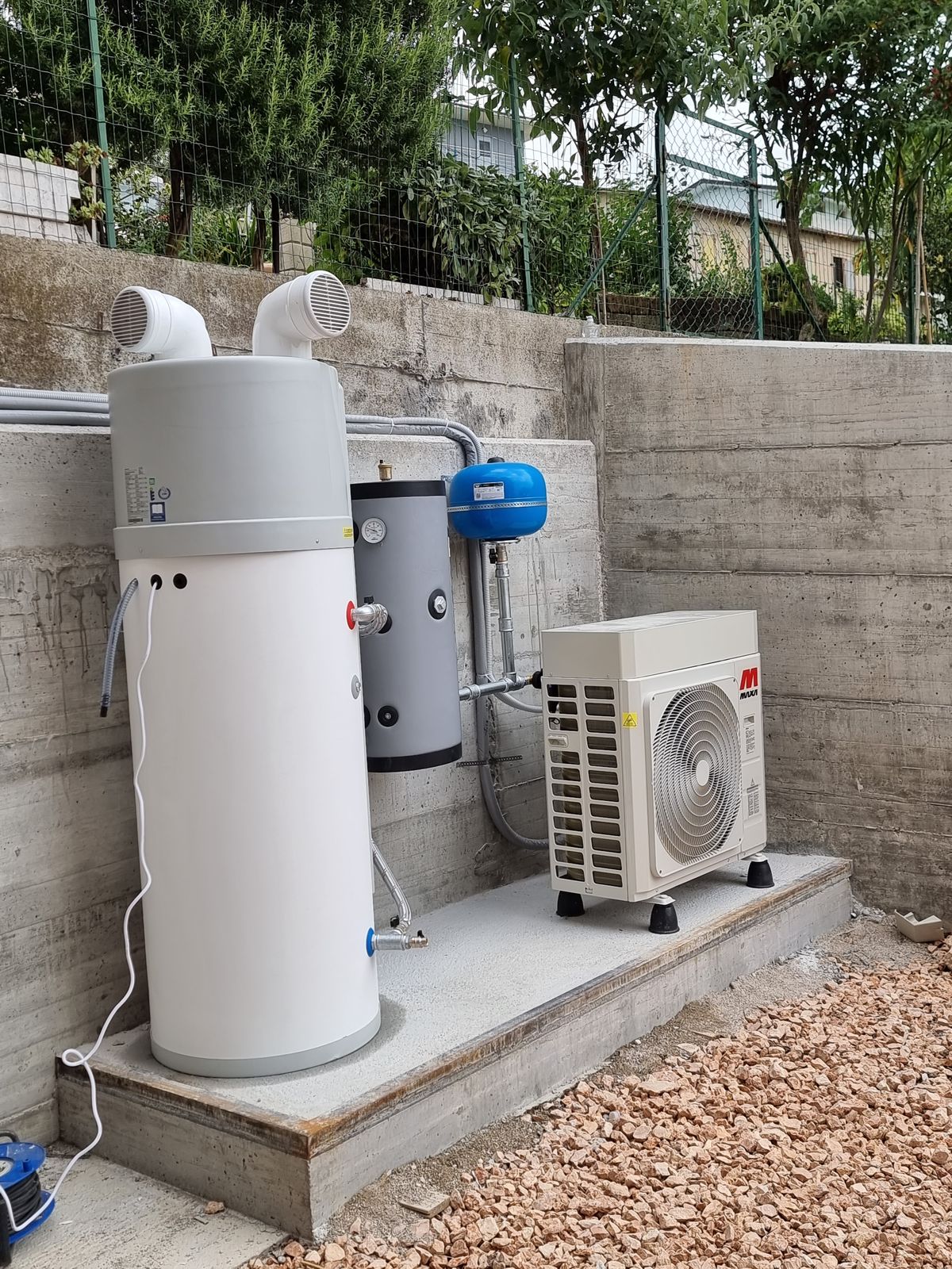Scaldacqua a pompa di calore e unità esterna installati su un basamento in cemento